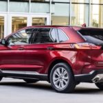 A red 2020 Ford Edge is parked outside of a Ford dealership.