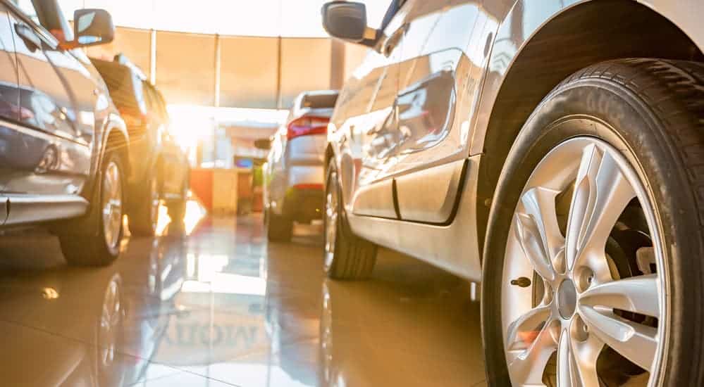 A close up used cars sitting in a showroom at a car dealership.