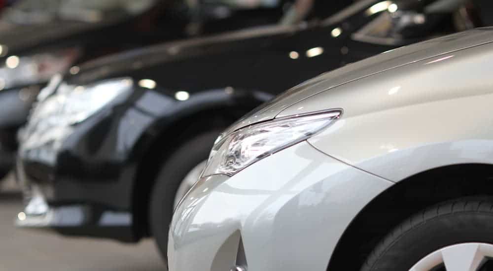 A close up of used cars in a row at a dealership that sells used cars under 15k