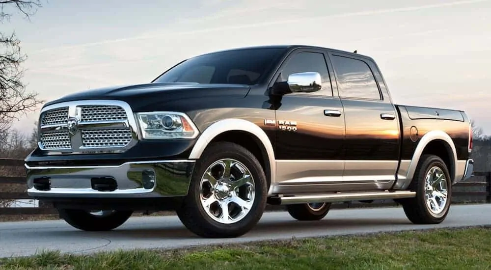 A black 2017 Ram 1500 is parked in a grass lined driveway at dusk.