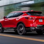 A red 2020 Chevy Blazer RS is driving down a city street.