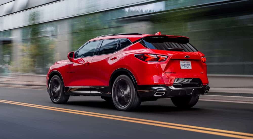 A red 2020 Chevy Blazer RS is driving down a city street.