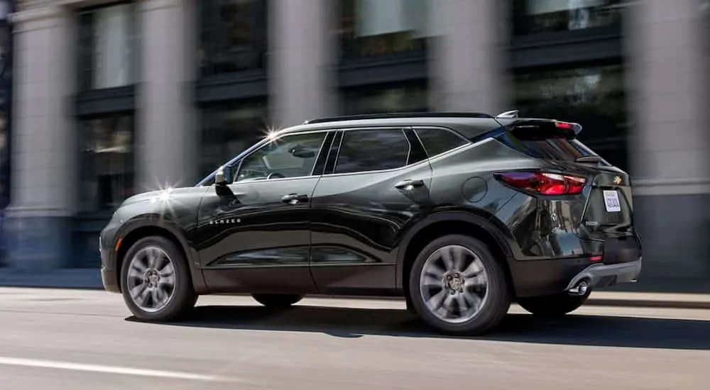 A green 2020 Chevy Blazer is driving on a city street.