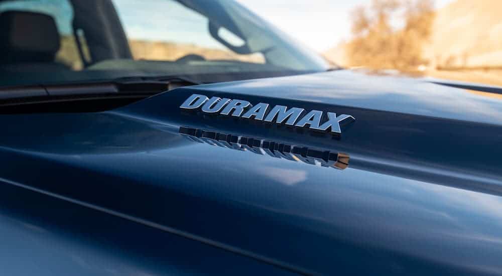 A close up of a Duramax badge on a 2020 Chevy Silverado 1500's hood is shown.