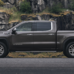 A brown 2020 GMC Sierra 1500 is parked in front of a rock wall.