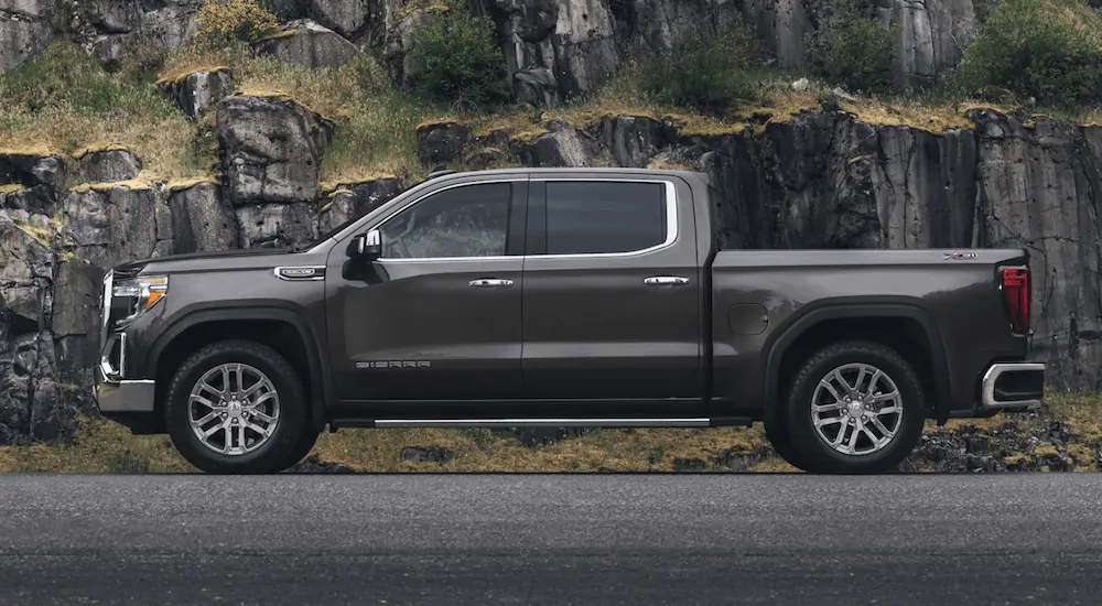 A brown 2020 GMC Sierra 1500 is parked in front of a rock wall.