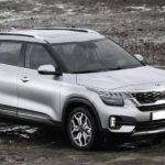 A silver 2020 Kia Seltos is parked in a muddy field.