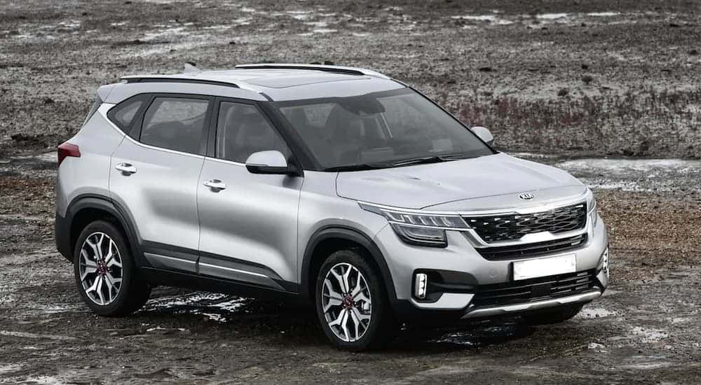 A silver 2020 Kia Seltos is parked in a muddy field.