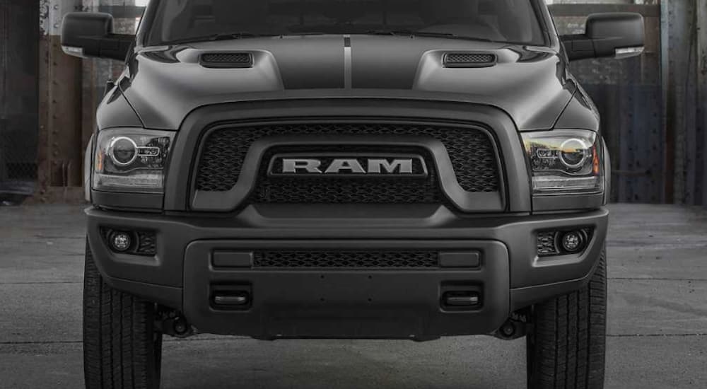 A close up of the black front grille on a Ram truck that says 'RAM' on it.