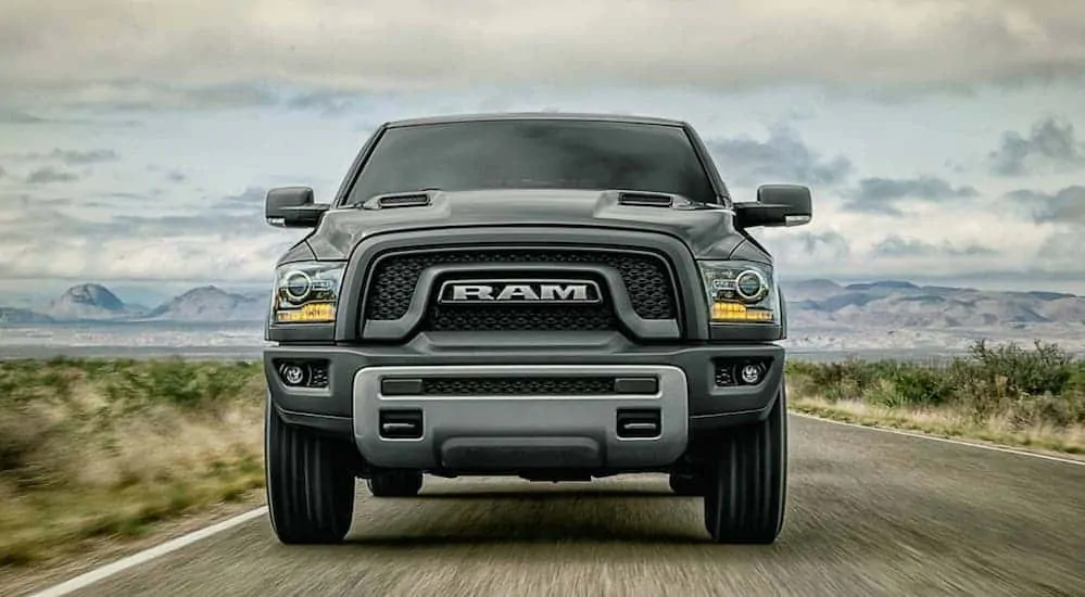 The front end of a black used 2018 Ram 1500 is shown on a highway.