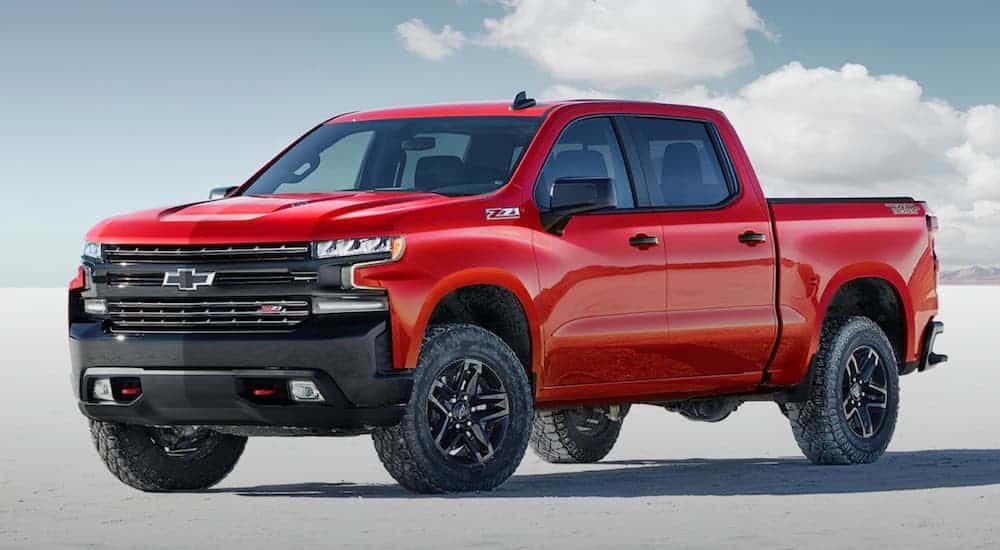 A red 2020 Chevy Silverado Trailboss, which wins when comparing the 2020 Chevy Silverado vs 2020 Ford F-150, is parked on a flat salt land.