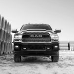 A black and white photo of a 2020 Ram 2500 from the front while parked next to concrete tubes.