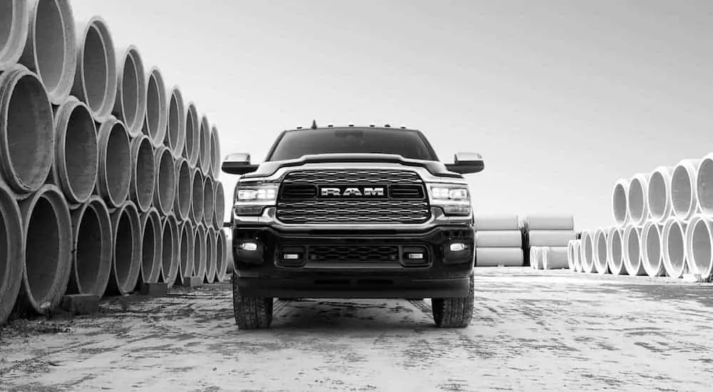 A black and white photo of a 2020 Ram 2500 from the front while parked next to concrete tubes.