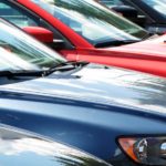 A row of used cars are on a used car lot.