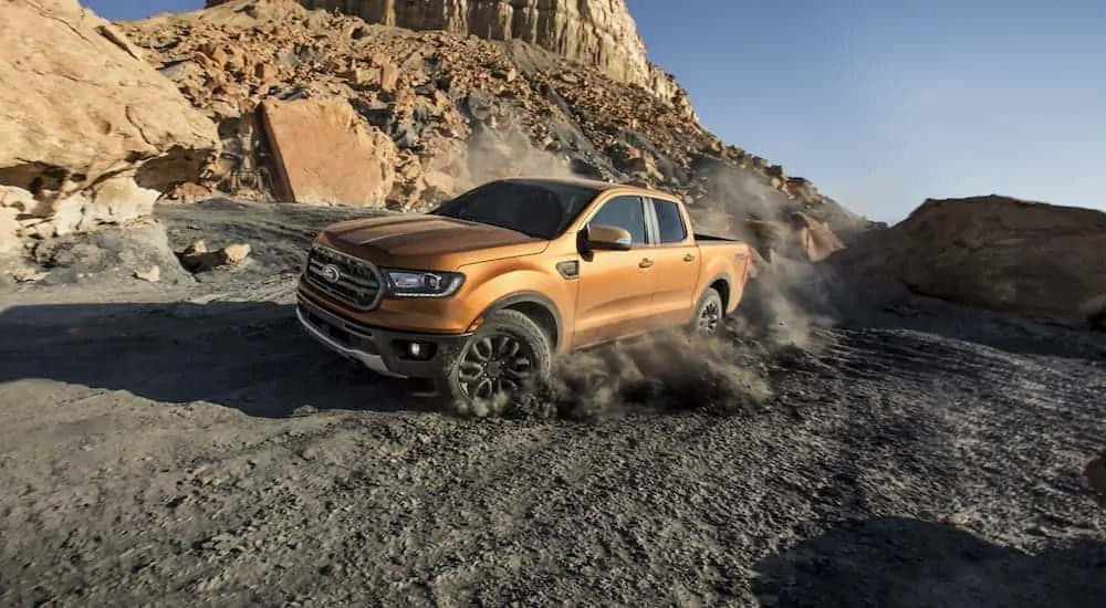 A gold colored 2020 Ford Ranger, which wins when comparing the 2020 Ford Ranger vs 2020 Toyota Tacoma, is off-roading in the desert.