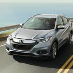 A silver 2020 Honda HR-V is driving along a bay.