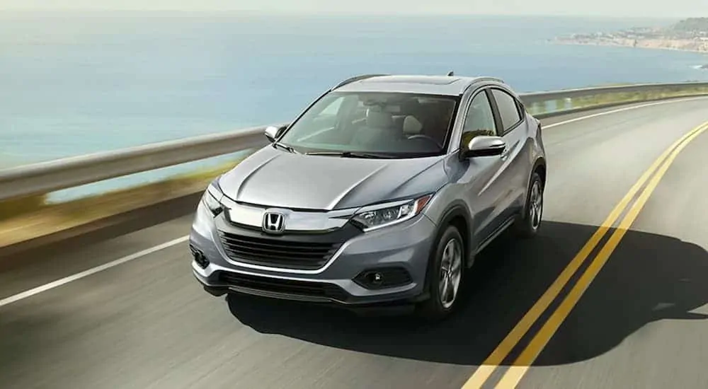 A silver 2020 Honda HR-V is driving along a bay.