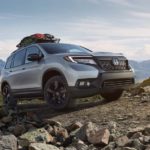 A silver 2020 Honda Passport Elite, one of the newer Honda SUVs, is off-roading in the mountains.