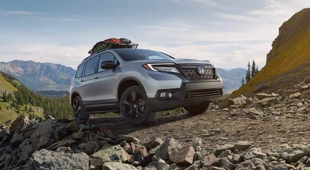 A silver 2020 Honda Passport Elite, one of the newer Honda SUVs, is off-roading in the mountains.