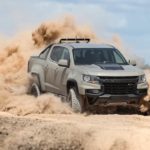 A tan 2021 Chevy Colorado ZR2 is kicking up sand in the desert.