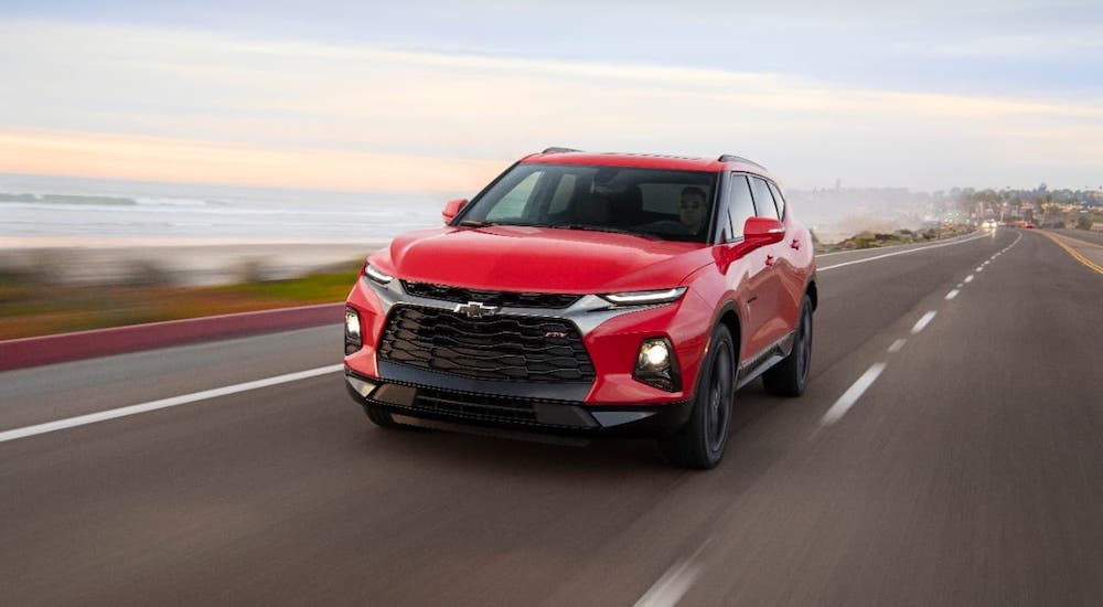 A red 2020 Chevy Blazer is driving on a highway after winning 2020 Chevy Blazer vs 2020 Ford Edge.