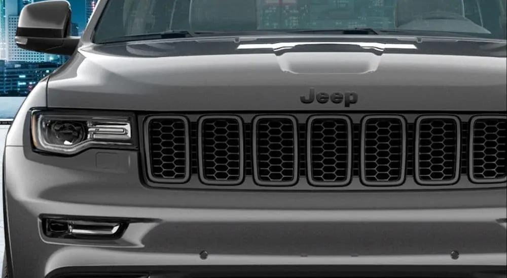 A closeup is shown of the grille on a gray 2020 Jeep Grand Cherokee High Altitude.