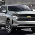 A silver 2021 Chevy Suburban is parked in a modern driveway.