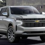 A silver 2021 Chevy Suburban is parked in a modern driveway.