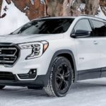 A white 2021 GMC Terrain AT4 is parked on a snowy road.