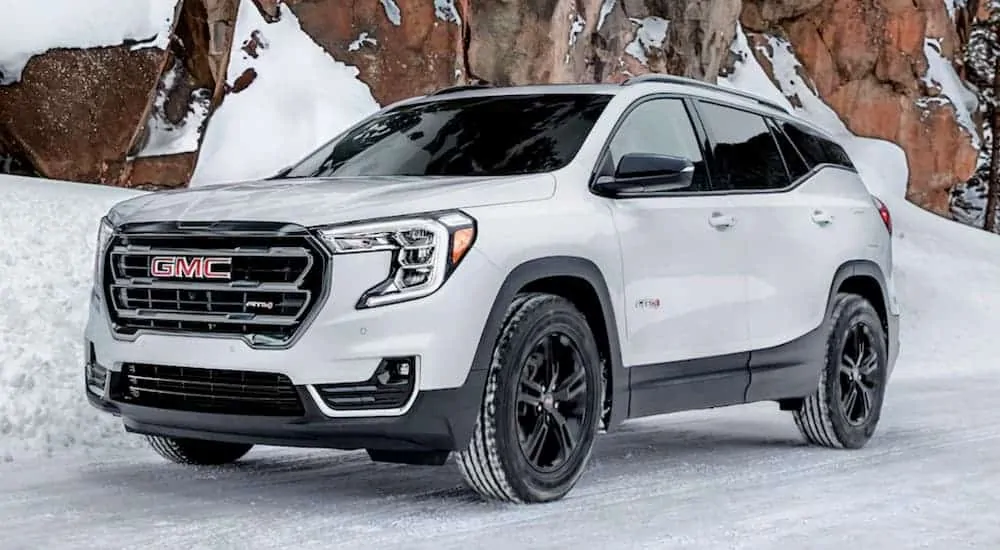 A white 2021 GMC Terrain AT4 is parked on a snowy road.