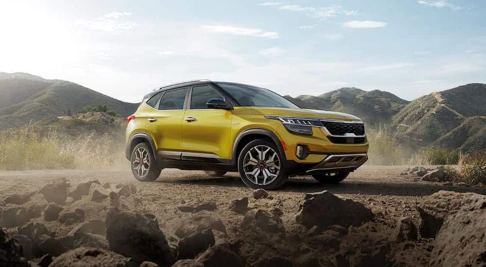 A yellow 2021 Kia Seltos is parked in the desert after leaving a Kia dealership near me.