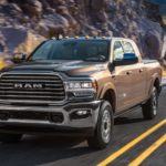 A brown 2020 Ram 2500 is driving on a highway, see one at your local Ram dealership.