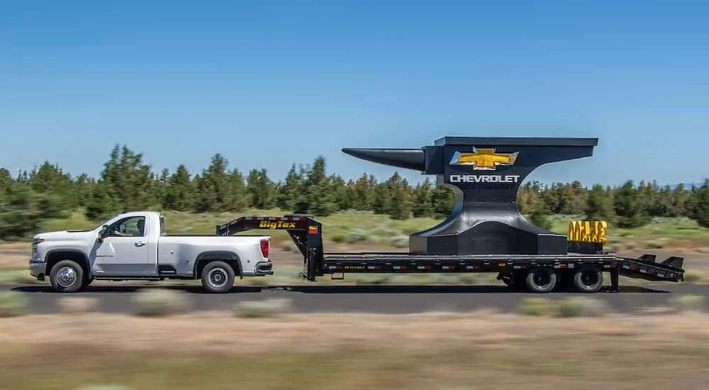 A white 2020 Chevy Silverado 3500HD is towing a massive anvil.