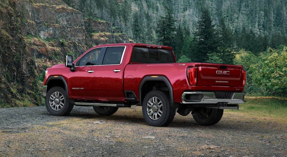 A red 2020 GMC Sierra 2500 is parked in front of rock hills and trees after winning the 2020 GMC Sierra 2500 vs 2020 Ford F-250 comparison.