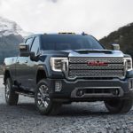 A grey 2020 GMC Sierra 2500 is parked on gravel in front of mountains after winning the 2020 GMC Sierra 2500 vs 2020 Ram 2500 comparison.