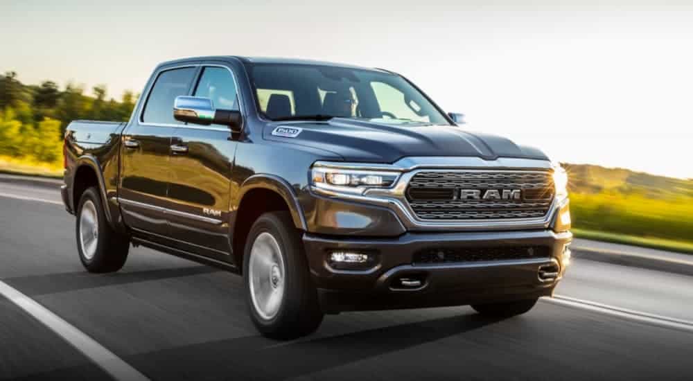 A grey 2020 Ram 1500 is driving along a sunny road after winning the 2020 Ram 1500 (new Ram) vs 2020 Chevy Silverado comparison.