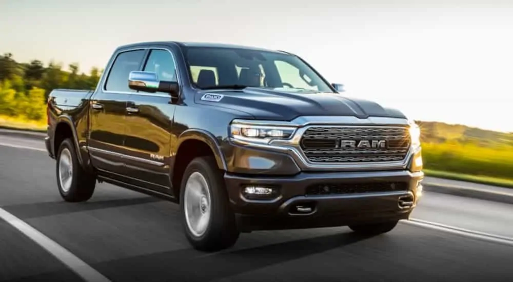 A grey 2020 Ram 1500 is driving along a sunny road after winning the 2020 Ram 1500 (new Ram) vs 2020 Chevy Silverado comparison.