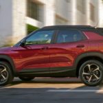 A red 2021 Chevy Trailblazer is driving on a city street.