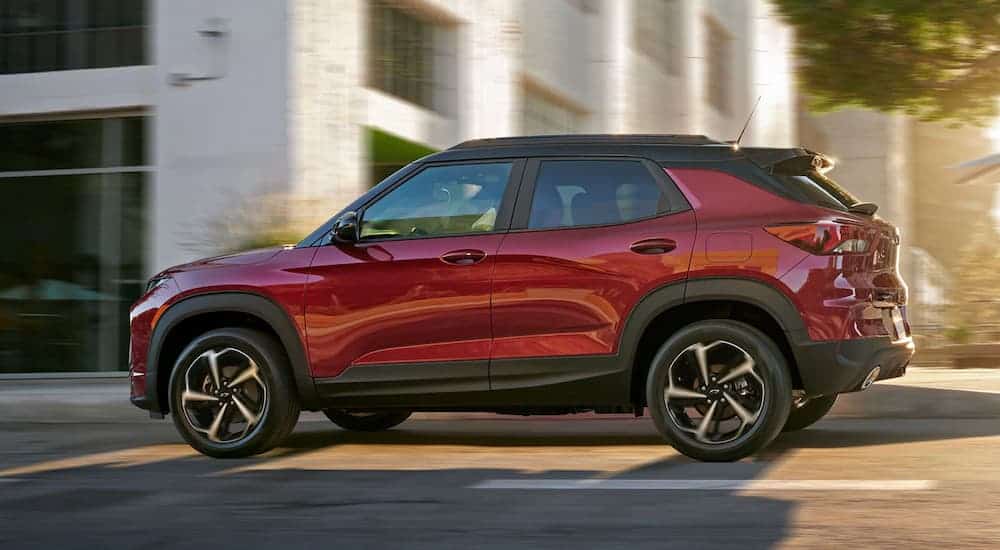 A red 2021 Chevy Trailblazer is driving on a city street.