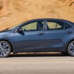 A blue 2018 Toyota Corolla XSE is driving in front of a rock face.