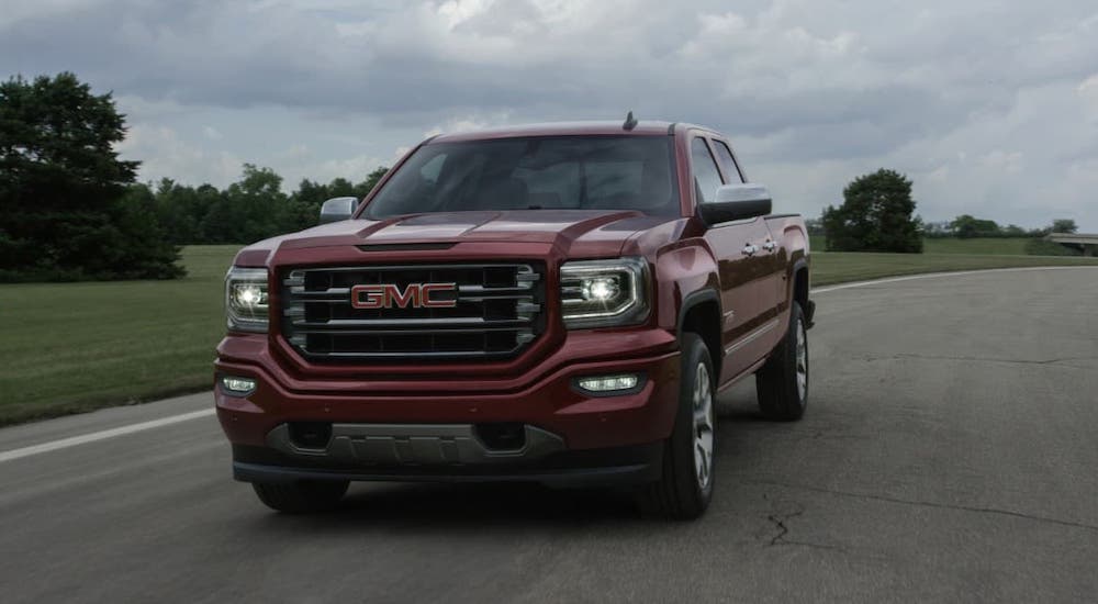 A red 2017 GMC Sierra 1500 is driving on a track.