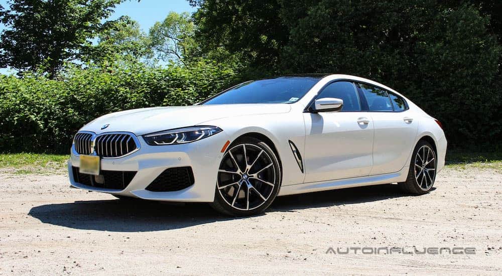A white 2020 BMW 840i Gran Coupe is angled forward and left in a dirt parking lot.