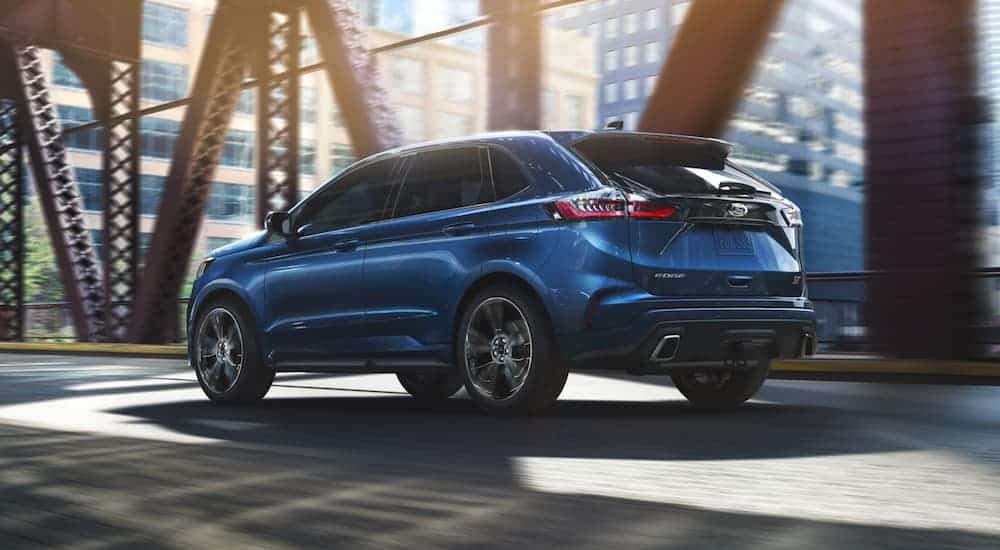 A blue 2020 Ford Edge is driving on a city bridge after winning the 2020 Ford Edge vs 2020 Chevy Blazer comparison.