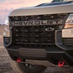 A closeup is showing the grille of a tan 2021 Chevy Colorado ZR2.