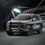 A gray 2021 Chevy Tahoe PPV is parked under a bridge at night.