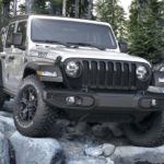 A silver 2020 Jeep Wrangler Unlimited Willy's Edition from a Jeep dealer near me is crawling over rocks, shown from the front.