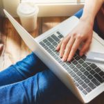 A woman is on her laptop doing some online car shopping.