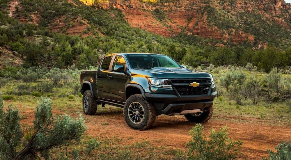 A green 2020 Chevy Colorado ZR2 is parked in a desert.