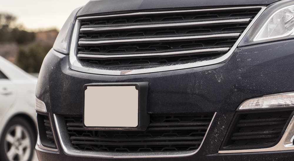 A closeup is shown of an empty license plate on a blue car at a Used Car Dealership Near Me.