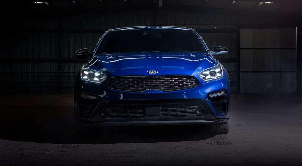 A blue 2020 Kia Forte is parked in a dark warehouse after winning the 2020 Kia Forte vs 2020 Toyota Corolla comparison.
